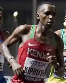 Black man in a red top running.