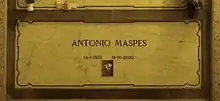 A marble gravestone on the wall of a crypt