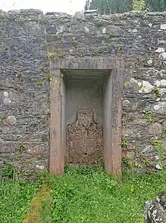 Blocked doorway with an armorial panel