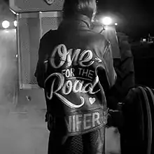 A black-and-white image of a woman wearing a leather jacket, with the title of the song on the back.