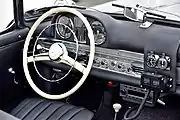 Black-and-white photo of a roadster interior, with additional equipment