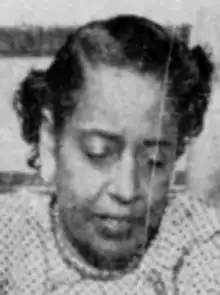 A Black woman with hair in a short set style, looking downward