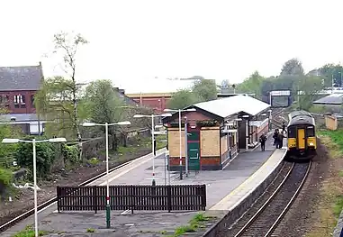 The entrance to a train station with a sign saying "Ashton" above the entrance