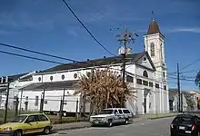 A large, white building with a spire, next to a road.