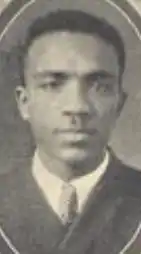 A yearbook photograph of an African-American man wearing a suit and tie; he has short hair and a mustache.