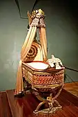 King of Rome's Cradle (Empire); by Pierre-Paul Prud'hon, Henri-Victor Roguier [fr], Jean-Baptiste-Claude Odiot and Pierre-Philippe Thomire; 1811; wood, silver gilt, mother-of-pearl, sheets of copper covered with velvet, silk and tulle, decorated with silver and gold thread; height: 216 cm; Kunsthistorisches Museum (Vienna, Austria)