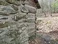 Exterior Chimney and corner detail with a stone retaining wall.