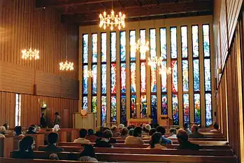 Inside Båtsfjord Church, facing the altar and the stained glass church windows.