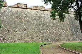 Large curtain wall with embrasures and arrowslits