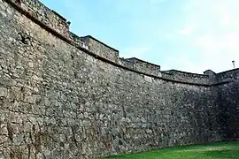 Concave curtain wall at west end with upper embrasures