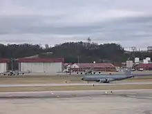 A KC-135R Stratotanker departing with the Alabama Air National Guard hangars and buildings behind.