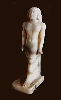 a small white statue of a man striding