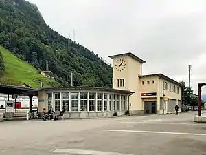 Two-story building with flat roof and adjoining clock tower