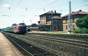 Train passes three-story brick building