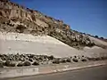 Road cut exposing Otowi Member in Pueblo Canyon. Above are cliffs of Tsherige Member.