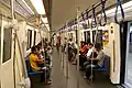 Interior of first generation trains. Noted only 1 row of handrails and hanging strap are present and with traditional route map above doors.