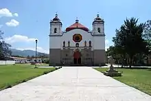 Church of San Bartolo with remains of pyramids to the left