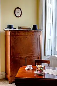 A desk, dresser, and hats on display