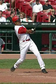 Barry Larkin follows through after a hit, wearing a Cincinnati Reds uniform