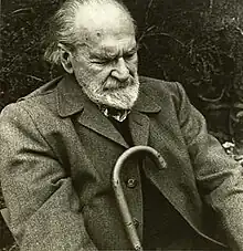 Black and white photograph of Basil Bunting, poet, in sitting position.