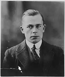 Photograph of a young man, his hair slicked and parted to the left, in a formal suit.