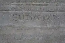 Detail of an engraved stone with a difficult-to-interpret inscription