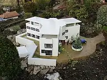 A white Modernist building with three wings