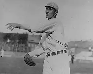 A black-and-white photograph of a man following through after throwing a baseball