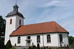 a small church with a bell tower and small graveyard