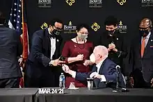 Sydnor receives a pen from Governor Larry Hogan after he signs into law a bill to end the state's longstanding lawsuit against its historically Black colleges and universities.