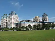 Apartment blocks of varying heights behind a field