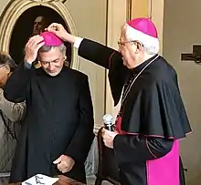 Bishop Malvestiti puts the zucchetto on the head of father Egidio Miragoli, just elected bishop of Mondovì, 29 September 2017