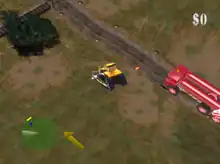 An industrial field with dirty grass and patches of dirt. A bulldozer is centered in the screenshot, traveling to the upper left towards railroad tracks and a bush. Nearby are lights along a road, both lit and unlit. Close behind is a red fire engine-like vehicle with two cylinders mounted atop, along its length. In the bottom left of the heads up display is a green radar circle showing obstacles in the upper left, and alongside the radar, a yellow arrow pointing to the upper left, indicating the location of the next structure in the red carrier truck's path. In the upper right of the heads up display is the number zero, preceded by a dollar sign, indicating that no damage to property has been scored.