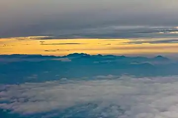 Anamudi as seen from an aircraft. The peak is in the center of the image with a small white cloud seen behind its rounded summit