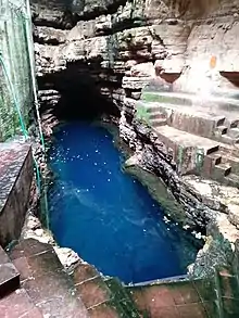 The water shines blue in Bhimkund cave.