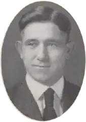 A young man facing camera wearing a suit coat and tie