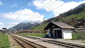 Shelter next to double-track railway line with mountains behind