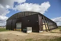 An aircraft hangar with support buttresses along its length