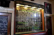 Blackboard with labels for names of train and destinations, but lists names of beers and other beverages instead