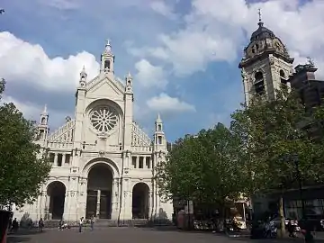 The current church's facade (left) and original church's tower (right)