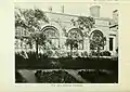 Sepia photograph of the outside of building with four arched windows