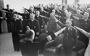 Black and white photograph of men wearing military uniforms giving the nazi salute