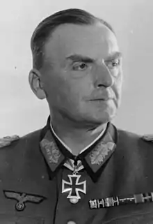 A man wearing a military uniform with an Iron Cross displayed at the front of his uniform collar.