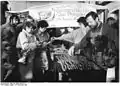 Border crossers being treated to free sausages, sandwiches, wine, coffee and cake on the Thuringian side of the new border crossing between Herleshausen and Lauchröden in Eisenach in December 1989.