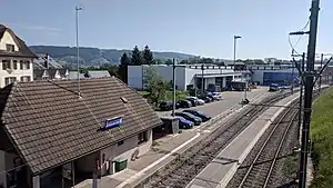 Building next to double-track railway line with side and island platforms