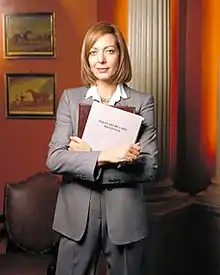 Allison Janney, pictured in costume as C. J. Cregg, for a promotional shoot