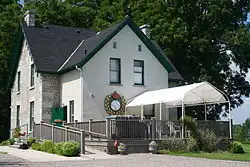 Two-storey house painted in white with green trim