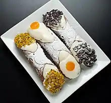 Cannoli with pistachio dust, candied and chocolate drops