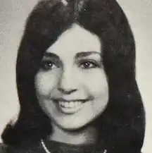 A smiling young white woman with dark hair and eyes