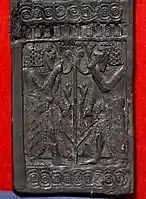 Carved ivory panel showing young bearded Egyptian men flanking lotus stem and flowers. From Nimrud, Iraq. Iraq Museum.